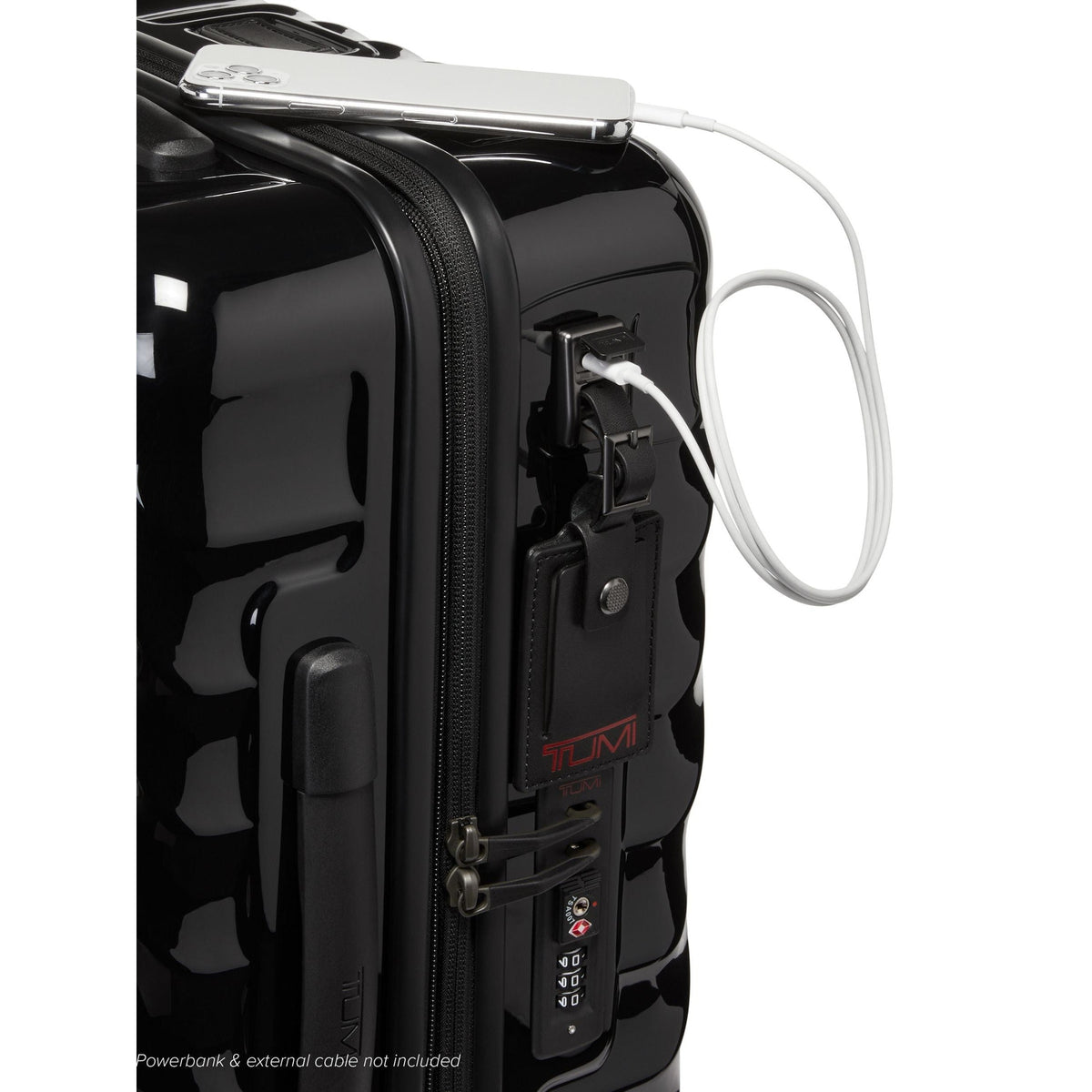 Tumi 19 Degree Continental black expandable hardside carry-on, USB port close-up with a phone charging on top, Tumi tag