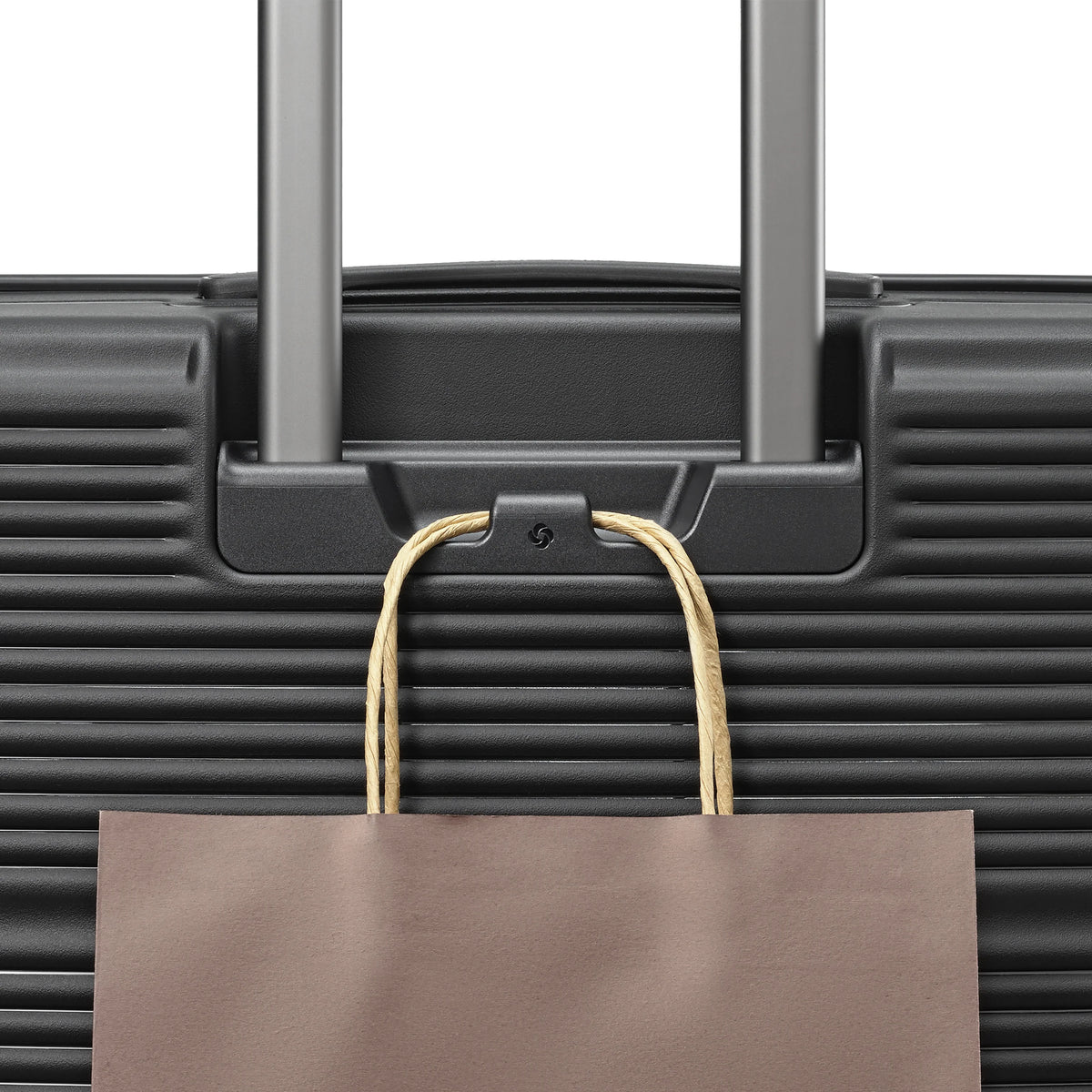 Samsonite Paralux Global black carry-on hardside spinner, add-a-bag hook holding a shopping bag