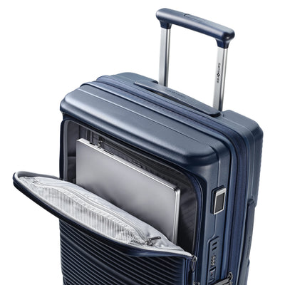Samsonite Paralux Global midnight navy carry-on hardside spinner, laptop sliding into the front-access sleeve