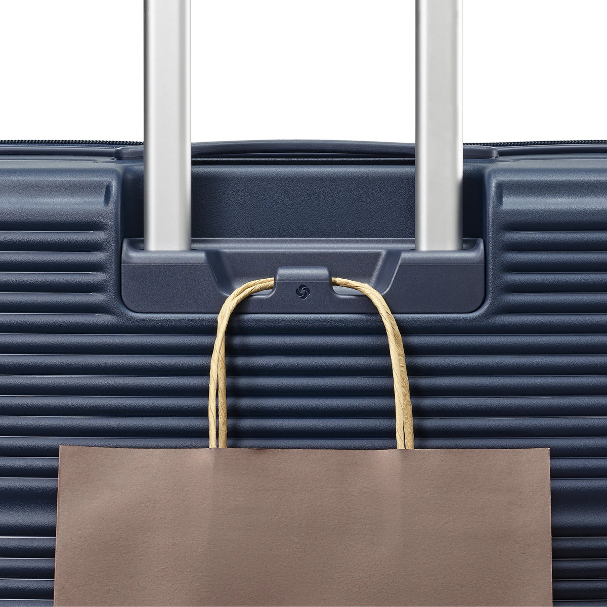 Samsonite Paralux midnight navy large checked hardside spinner, add-a-bag hook holding a shopping bag
